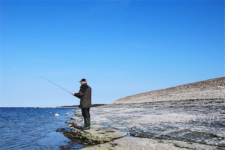 simsearch:400-07501738,k - Man fishing at a flat rock coast at blue sky and blue water. From the swedish island Oland in Sweden. Photographie de stock - Aubaine LD & Abonnement, Code: 400-07508611