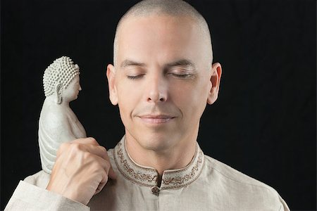 Close-up of a buddhist meditating, holding a stone buddha statue. Photographie de stock - Aubaine LD & Abonnement, Code: 400-07508955