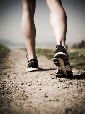 simsearch:400-07682342,k - Photo of the legs and shoes of a young woman jogging on a gravel path down a country path. Heavily filtered for atmosphere. Stock Photo - Budget Royalty-Free & Subscription, Code: 400-07509635