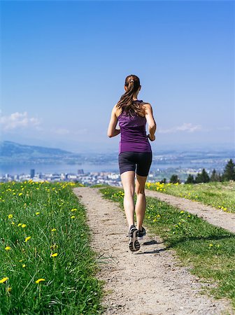 simsearch:400-07682342,k - Photo of a young woman jogging and exercising on a country path.  Lake and city in the distance. Slight motion blur visible. Stock Photo - Budget Royalty-Free & Subscription, Code: 400-07509643