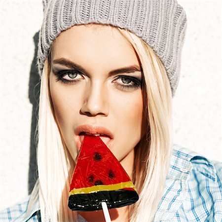 simsearch:400-07509968,k - Beautiful sexy blond girl with smokey eye makeup licks watermelon lollipop with her plump passionate lips Stock Photo - Budget Royalty-Free & Subscription, Code: 400-07509964