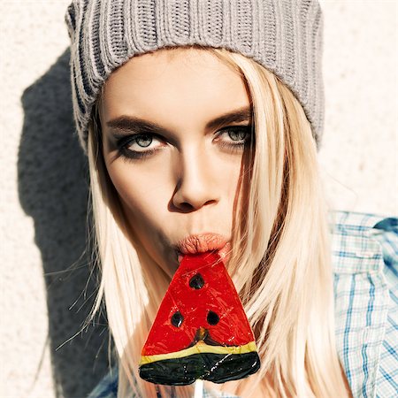 simsearch:400-07509968,k - Portrait of sexy blond girl with smokey eye makeup who sucks watermelon lollipop with her plump passionate lips Stock Photo - Budget Royalty-Free & Subscription, Code: 400-07509965