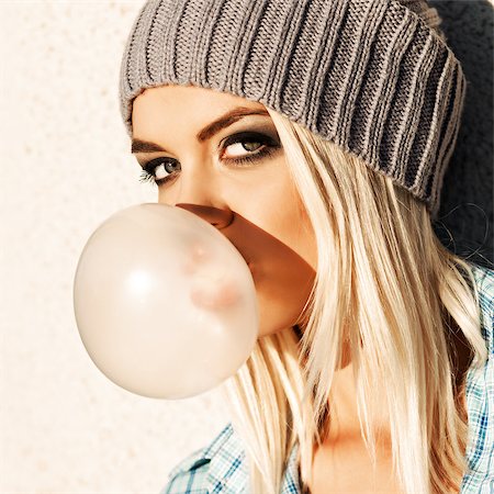 simsearch:400-07509968,k - Close-up of beautiful young blond girl in beanie hat blows big bubble from bubble gum Stock Photo - Budget Royalty-Free & Subscription, Code: 400-07509971