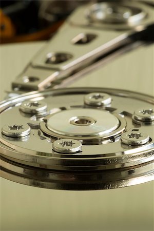 The inside of a hard disk drive.  The platter and the arm that read the platter with green lighting: macro shot. Stock Photo - Budget Royalty-Free & Subscription, Code: 400-07503363