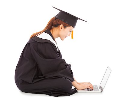 female graduation sitting and  typing on a laptop Foto de stock - Super Valor sin royalties y Suscripción, Código: 400-07514195