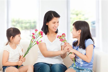 two daughters handing mother carnations Stock Photo - Budget Royalty-Free & Subscription, Code: 400-07514192