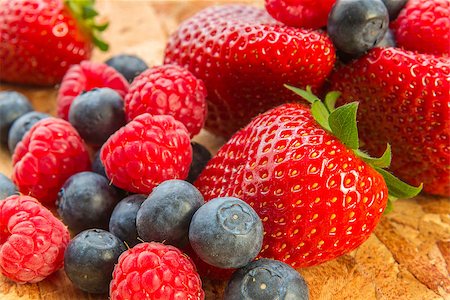 porridge and berries - ripe fresh raspberries, strawberries and blueberries on wooden tray Stock Photo - Budget Royalty-Free & Subscription, Code: 400-07514836