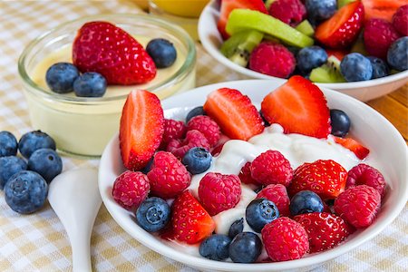 porridge and berries - sweet berries of raspberries, strawberries and blueberries, in small bowls with orange juice on coverlet Stock Photo - Budget Royalty-Free & Subscription, Code: 400-07514837