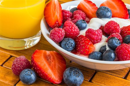 porridge and berries - sweet berry of raspberries, strawberries and blueberries in yoghurt on wooden tray with orange juice, healthy breakfast Stock Photo - Budget Royalty-Free & Subscription, Code: 400-07514839