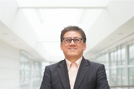 simsearch:400-07515329,k - Portrait of 60s Asian Chinese CEO boss smiling. Senior male businessman, real modern office building as background. Stock Photo - Budget Royalty-Free & Subscription, Code: 400-07515316