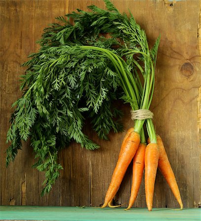 simsearch:400-07982459,k - fresh organic carrots with green leaves on a wooden background Photographie de stock - Aubaine LD & Abonnement, Code: 400-07515755