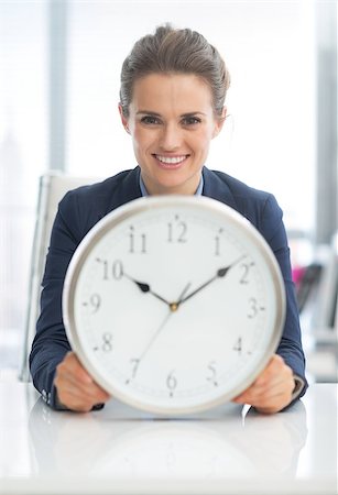 Smiling business woman holding clock Stock Photo - Budget Royalty-Free & Subscription, Code: 400-07516792