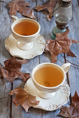 Green tea in vintage mugs on wooden table with dry fall leaves. Selective focus. Stock Photo - Budget Royalty-Free & Subscription, Code: 400-07516987