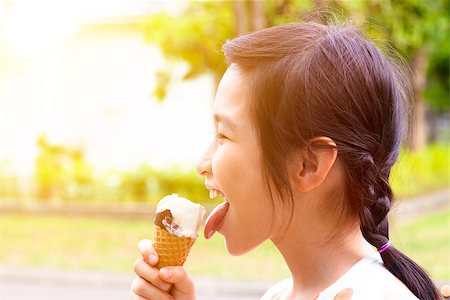 happy little girl eating popsicle with sunset background Foto de stock - Super Valor sin royalties y Suscripción, Código: 400-07517984