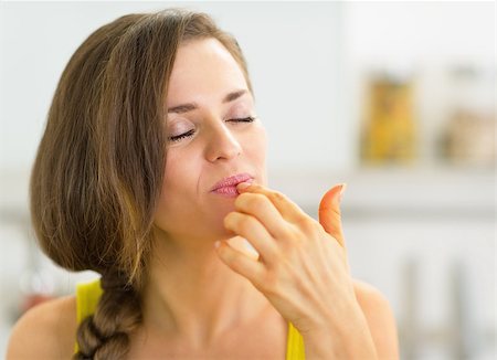 finger licking food - Young woman in kitchen licking fingers Stock Photo - Budget Royalty-Free & Subscription, Code: 400-07518432