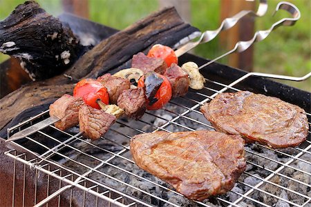 simsearch:400-07518553,k - Cooking on the barbecue grill assortment sausages steak and skewers Photographie de stock - Aubaine LD & Abonnement, Code: 400-07518554