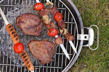 simsearch:400-07518553,k - Cooking on the barbecue grill assortment sausages steak and skewers Photographie de stock - Aubaine LD & Abonnement, Code: 400-07518556