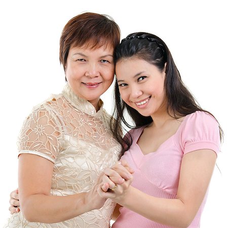 Mixed race Asian family portrait. Elderly mother and adult daughter holding hands bonding isolated on white background. Stock Photo - Budget Royalty-Free & Subscription, Code: 400-07518989