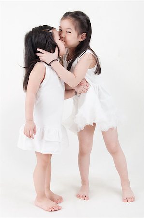 simsearch:400-07173561,k - Little girls portrait. Asian sister kissing sibling on plain background. Foto de stock - Royalty-Free Super Valor e Assinatura, Número: 400-07518980