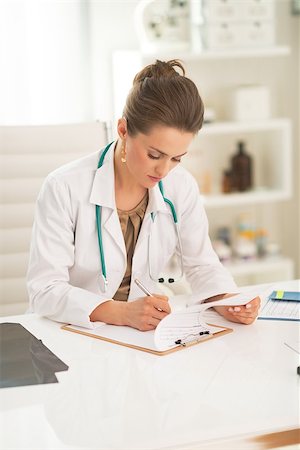 simsearch:400-07099882,k - Medical doctor woman writing in clipboard Photographie de stock - Aubaine LD & Abonnement, Code: 400-07519209