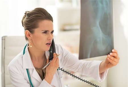 simsearch:400-07519214,k - Medical doctor woman looking on fluorography and talking phone Stock Photo - Budget Royalty-Free & Subscription, Code: 400-07519220