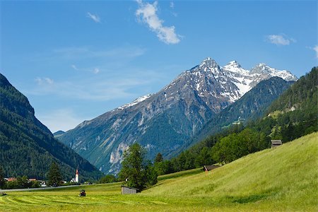 Summer Alpine mountain country view with grassy meadow and road to village (Austria) Stock Photo - Budget Royalty-Free & Subscription, Code: 400-07519271