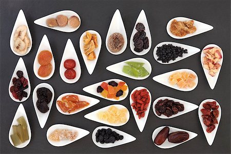 simsearch:400-08618279,k - Large dried fruit selection in white dishes over slate background. Photographie de stock - Aubaine LD & Abonnement, Code: 400-07510801