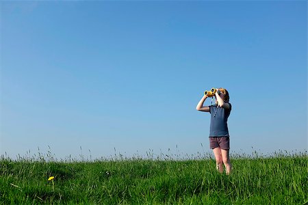 simsearch:400-06744095,k - Young girl with binoculars in a meadow searching the sky Stock Photo - Budget Royalty-Free & Subscription, Code: 400-07511369