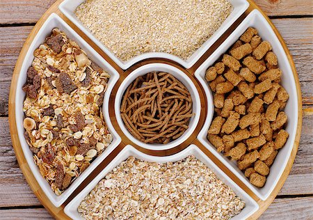 Various Muesli, Oat Flakes and Bran in White Plates closeup on Wooden background Stock Photo - Budget Royalty-Free & Subscription, Code: 400-07511535