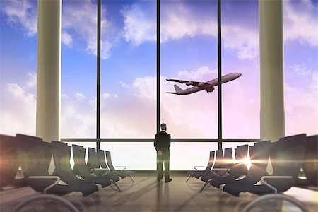 Rear view of mature businessman posing against airplane flying past departures lounge Stock Photo - Budget Royalty-Free & Subscription, Code: 400-07512333