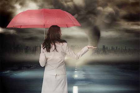 simsearch:400-07446838,k - Businesswoman holding umbrella against stormy sky with tornado over road Photographie de stock - Aubaine LD & Abonnement, Code: 400-07512413