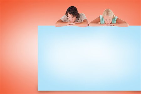 Attractive couple showing blue card on orange background Stock Photo - Budget Royalty-Free & Subscription, Code: 400-07512428