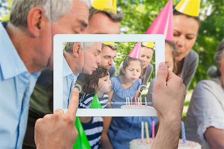 family with tablet in the park - Hand holding tablet pc showing family celebrating little girls birthday in the park Photographie de stock - Aubaine LD & Abonnement, Code: 400-07512445