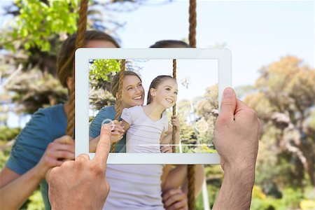 family with tablet in the park - Hand holding tablet pc showing mother pushing her daughter on a swing Photographie de stock - Aubaine LD & Abonnement, Code: 400-07512468