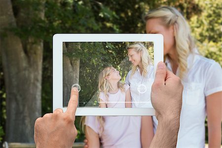 family with tablet in the park - Hand holding tablet pc showing blonde mother and daughter in park Photographie de stock - Aubaine LD & Abonnement, Code: 400-07512469