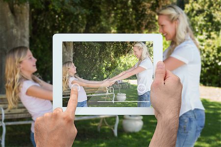 family with tablet in the park - Hand holding tablet pc showing blonde mother and daughter in park Photographie de stock - Aubaine LD & Abonnement, Code: 400-07512470