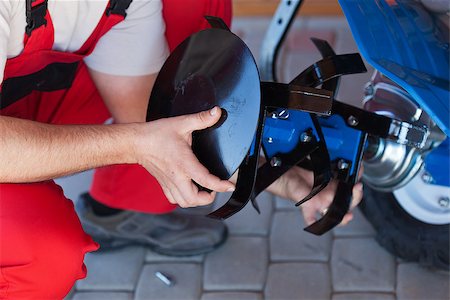 Worker mounting tilling accessory on a cultivator machine - closeup on hands Stock Photo - Budget Royalty-Free & Subscription, Code: 400-07524301