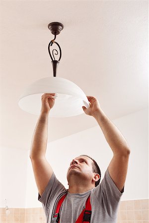 Electrician man screwing a new lightbulb into ceiling lamp - closeup Stock Photo - Budget Royalty-Free & Subscription, Code: 400-07524933