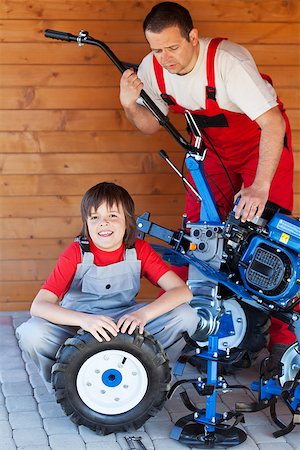 Man and boy servicing a cultivator machine together - closeup Stock Photo - Budget Royalty-Free & Subscription, Code: 400-07524996