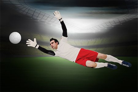 saving world - Goalkeeper in white making a save in a large football stadium with lights Photographie de stock - Aubaine LD & Abonnement, Code: 400-07525917