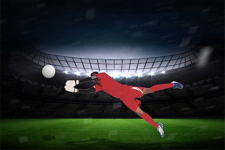 simsearch:400-07665266,k - Goalkeeper in red making a save against large football stadium with fans in yellow Stock Photo - Budget Royalty-Free & Subscription, Code: 400-07526202