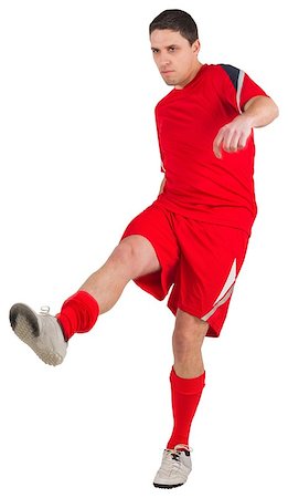 football man kicking white background - Fit young football player kicking on white background Stock Photo - Budget Royalty-Free & Subscription, Code: 400-07526881