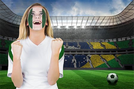 Excited nigeria fan in face paint cheering against large football stadium with brasilian fans Stock Photo - Budget Royalty-Free & Subscription, Code: 400-07528214