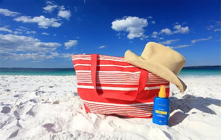 Summer sun protection at the beach, each hat and sunscreen on the sand at he beach.  Logos removed Photographie de stock - Aubaine LD & Abonnement, Code: 400-07528905