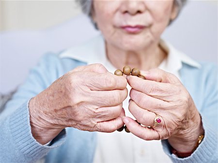 hands of a senior asian woman turning a set of prayer beads. Stock Photo - Budget Royalty-Free & Subscription, Code: 400-07545084