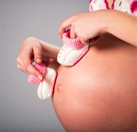 simsearch:400-07892390,k - Pregnant woman holding a pair of pink baby booties Photographie de stock - Aubaine LD & Abonnement, Code: 400-07546212