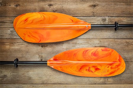 two blades of  colorful take-a-part kayak paddle with scrambled eggs pattern against weathered wood deck Stock Photo - Budget Royalty-Free & Subscription, Code: 400-07546787