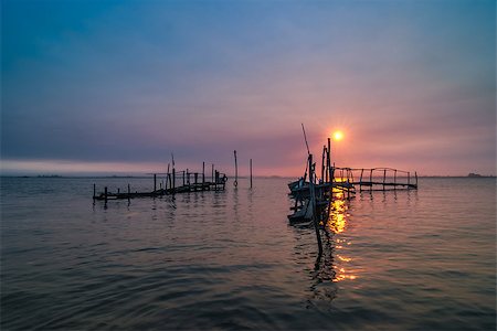 simsearch:400-08812531,k - Old fishing dock sunrise and calm water reflection. Fotografie stock - Microstock e Abbonamento, Codice: 400-07548911