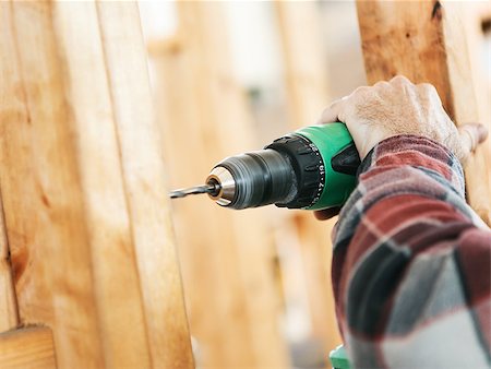 Closeup of a carpenter's hands using a drill on a construction site.  Focus on drill and hand.  Shallow depth of field. Stock Photo - Budget Royalty-Free & Subscription, Code: 400-07554261