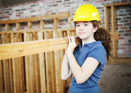 female workers in hard hats and tools - Young female apprentice carrying boards on a construction site. Stock Photo - Budget Royalty-Free & Subscription, Code: 400-07554296